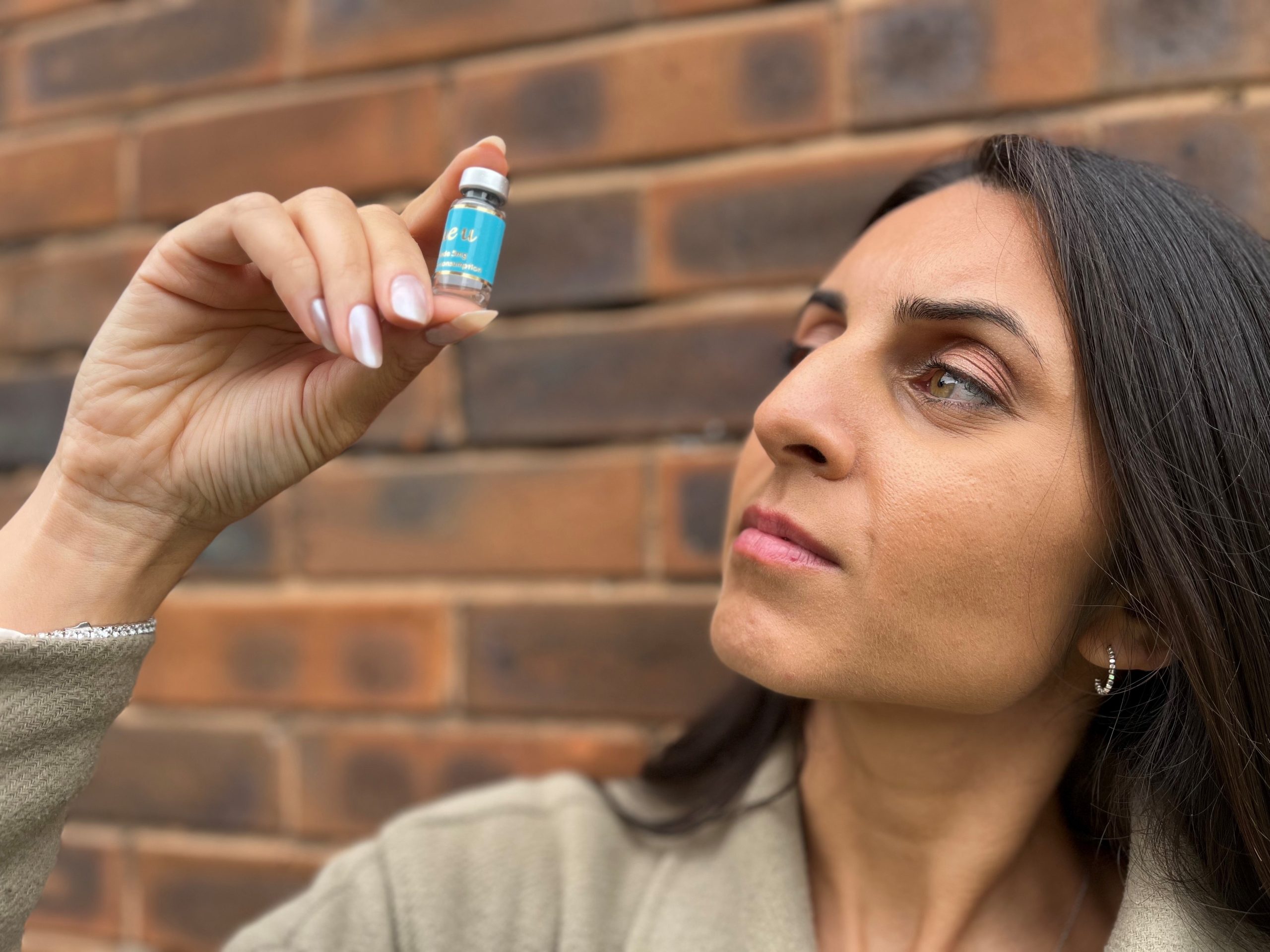 Journalist Pria looks at a vial of the skinny jab liquid